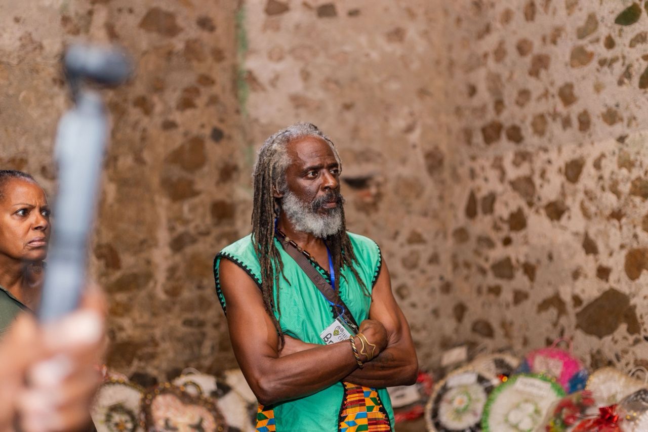Brian Templeton at traditional marketplace wearing green traditional clothing, engaged in cultural experience